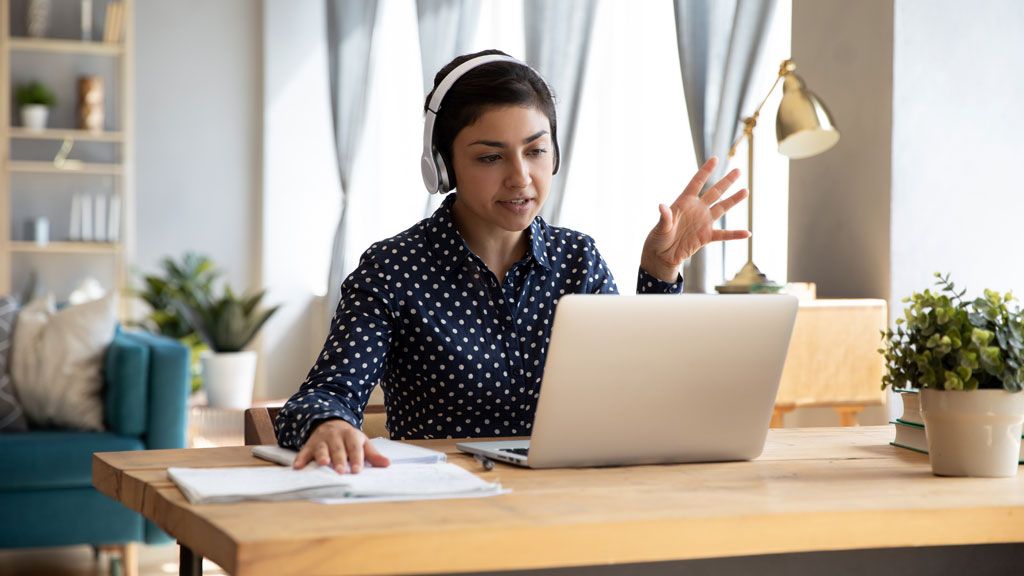 Jeune professionnel européen travaillant sur ordinateur portable dans appartement lumineux